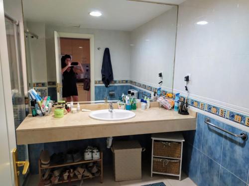 コラレホにあるAppartamento privato Oasis Tamarindoの浴室の洗面台を撮影した女性