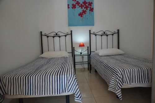 カジャオ・サルバヘにあるCallao Beach holiday homeのベッド2台が隣同士に設置された部屋です。