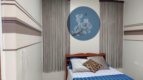 a bedroom with a bed with a blue circle on the wall at Rumanija's Airport Rooms in Zanderij