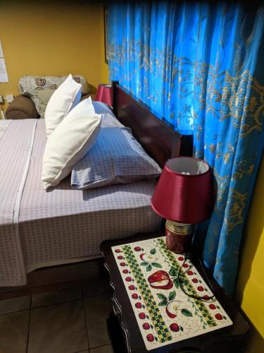 a bedroom with a bed and a table with a lamp at Ultimate Freedom Bed and Breakfast in Santa Cruz