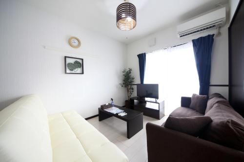 sala de estar con sofá y mesa en EX Itoman Apartment 203, en Itoman