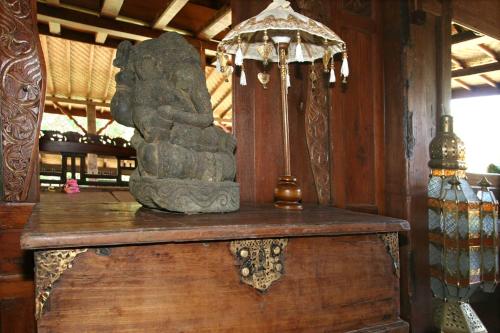 a statue sitting on top of a wooden table at Hotel Pondok Sari Beach & SPA Resort in Pemuteran