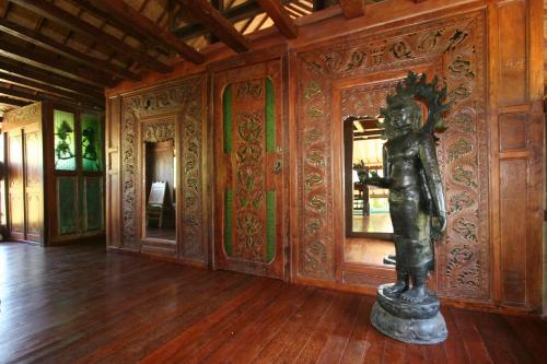 a statue in a room with a wooden wall at Hotel Pondok Sari Beach & SPA Resort in Pemuteran