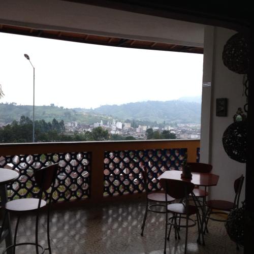 a room with tables and chairs and a large window at Hotel Faroazul RNT12633 in Santa Rosa de Cabal