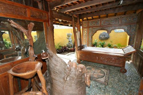 a bathroom with a tree stump chair and a sink at Hotel Pondok Sari Beach & SPA Resort in Pemuteran