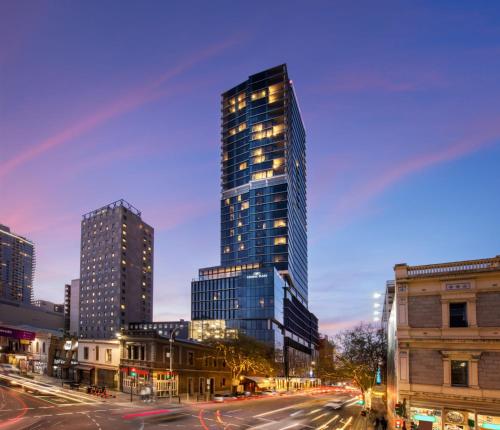 a tall skyscraper in a city at night at Crowne Plaza Adelaide by IHG in Adelaide