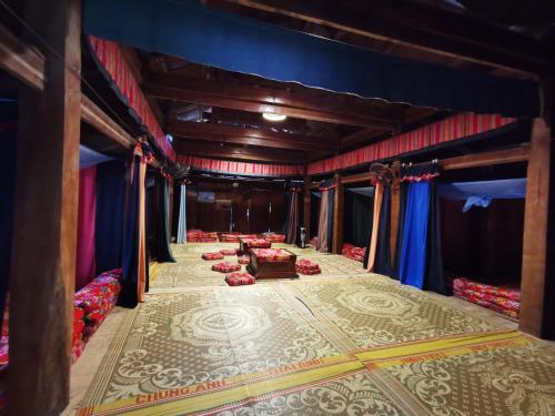 a room with a stage with couches and curtains at Lo Lo Homestay & Cafe Meo Vac in Mèo Vạc
