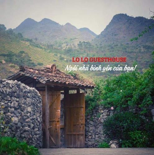 a sign that says crore satisfaction next to a stone building at Lo Lo Homestay & Cafe Meo Vac in Mèo Vạc
