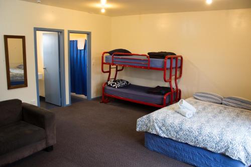 a room with two bunk beds and a chair at The Lazy Shag Lodge in Kaikoura