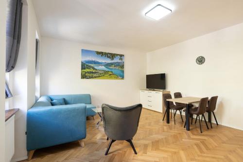 un soggiorno con divano blu e tavolo di Apartsee Wellness Plzeň a Plzeň