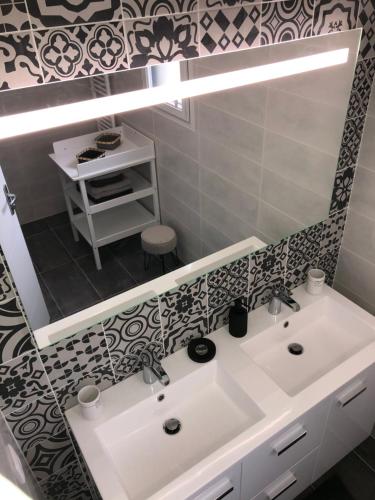 une salle de bain avec un lavabo blanc et un miroir dans l'établissement La Casita, à Chasseneuil-du-Poitou