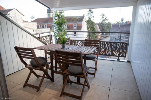 a wooden table and chairs on a balcony at Modern Living in Huningue