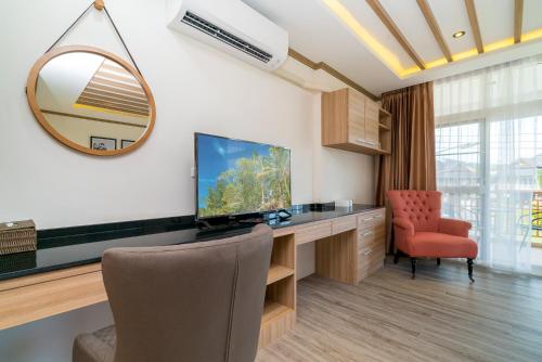 a room with a desk with a television and a chair at Phuket9 Residence in Chalong 