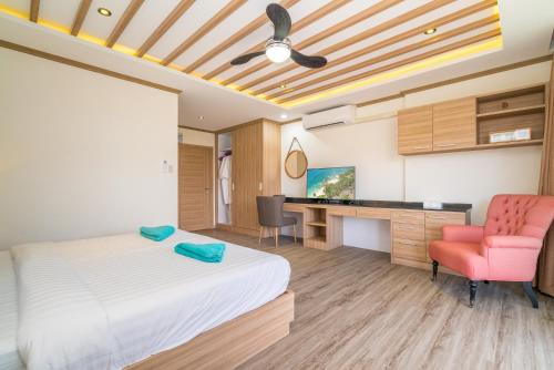 a bedroom with a bed and a desk and a chair at Phuket9 Residence in Chalong 