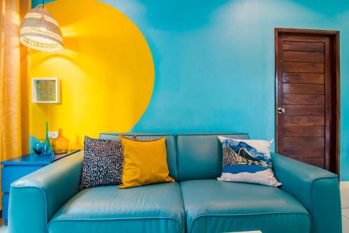 a blue couch with colorful pillows on it in a room at Villa Na Pran, Pool Villa in Pran Buri