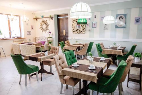 un restaurante con mesas de madera y sillas verdes en Apart Hotel Yesenin, en Kurgán