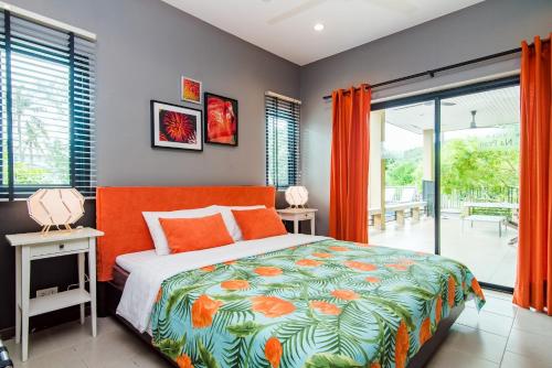 1 dormitorio con 1 cama con colcha de color naranja en Villa Na Pran, Pool Villa en Pran Buri