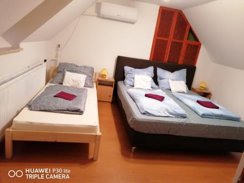 a bedroom with two beds with red towels on them at Barackos Vendégház Bár in Bár