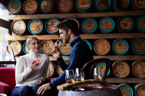 een man en een vrouw die wijn drinken in een wijnkelder bij RACV Hobart Hotel in Hobart