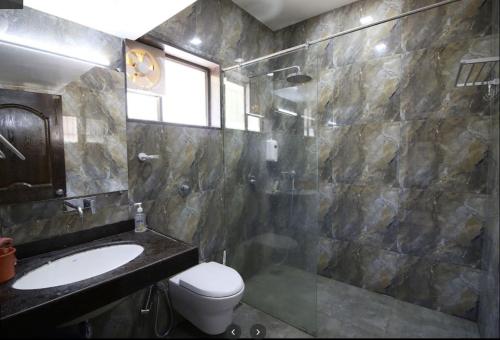 ein Bad mit einem WC, einem Waschbecken und einer Dusche in der Unterkunft Private pool Bungalow in Nashik in Deolāli