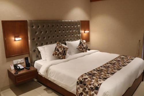 a bedroom with a large bed in a hotel room at SK Lords Inn Ahmedabad in Ahmedabad