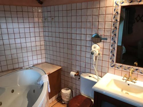 ein Badezimmer mit einer Badewanne, einem Waschbecken und einem Spiegel in der Unterkunft Casa rural calRei in Lles