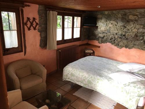a bedroom with a bed and a chair and windows at Casa rural calRei in Lles