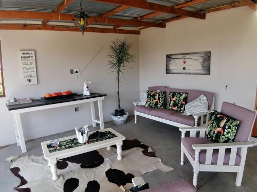 ein Wohnzimmer mit 2 Sofas und einem Tisch in der Unterkunft Forellenhof Guest Farm in Wakkerstroom