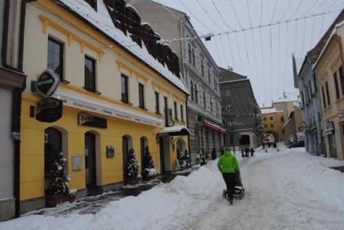 a person riding a bike down a snow covered street at Penzión ÁTRIUM in Prešov