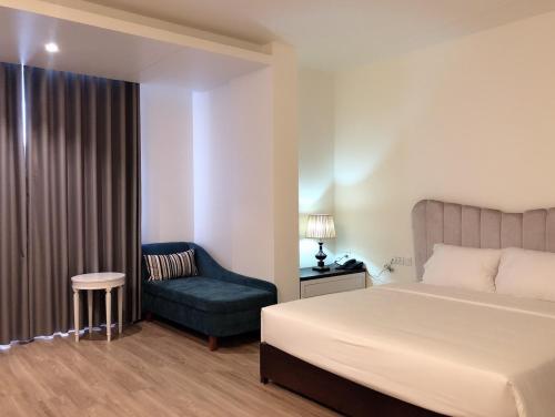1 dormitorio con 1 cama y 1 silla en Lotus Hotel & Apartment, en Hai Phong