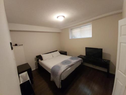 um quarto com uma cama e uma televisão de ecrã plano em Parson Creek em Fort McMurray