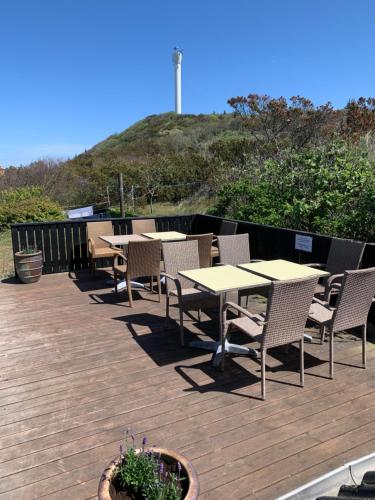 a row of tables and chairs on a wooden deck at Pakhuset Anholt in Anholt