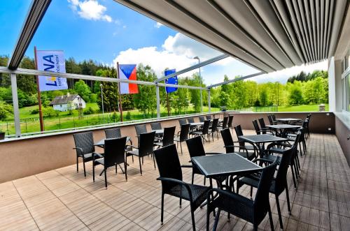 a restaurant with tables and chairs and windows at Hotel Resort Luna in Ledeč nad Sázavou