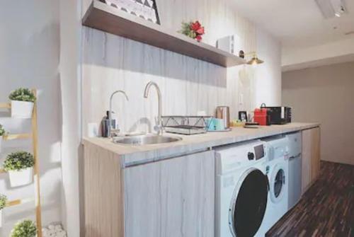 a kitchen with a sink and a washing machine at MU House in Taipei