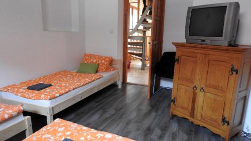 a small room with a bed and a tv on a cabinet at Barackos Vendégház Bár in Bár