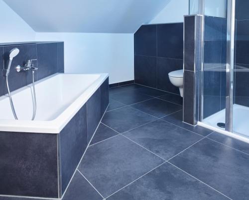 a bathroom with a bath tub and a toilet at Luxusapartment Burgschänke in Kaiserslautern