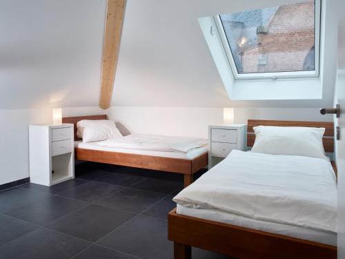 two beds in a room with a window at Luxusapartment Burgschänke in Kaiserslautern
