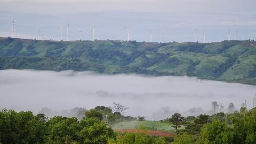 a misty lake with trees and hills in the background at ภูน้ำทิพย์ รีสอร์ท in Ban Huai Phai