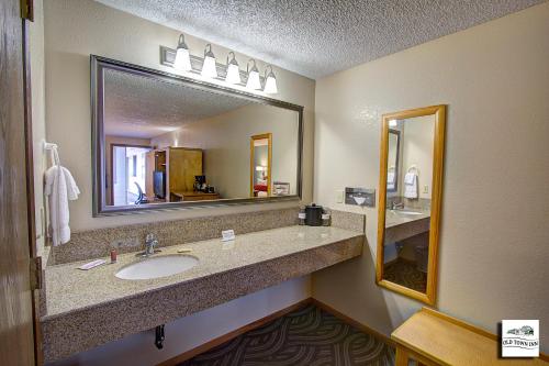 a bathroom with a sink and a large mirror at Old Town Inn in Florence