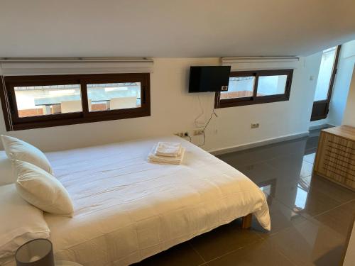 Poyales del HoyoにあるAPARTAMENTOS FUENTE ARRIBAのベッドルーム1室(白いベッド1台、窓2つ付)