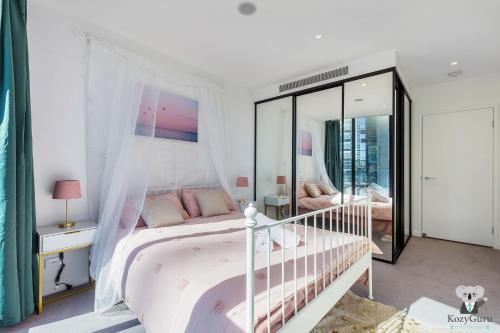 um quarto branco com uma cama de dossel em KOZYGURU FORTITUDE VALLEY HOLIDAY STYLE 2 BED APT FREE PARKING QFV211-1601 em Brisbane