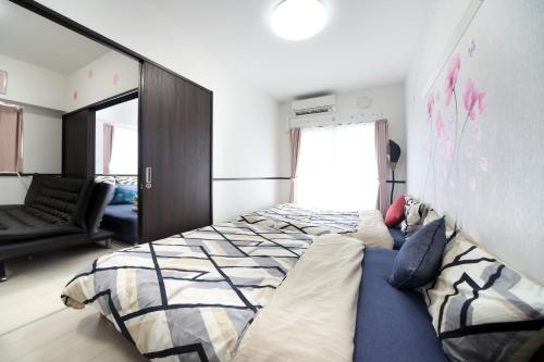 1 dormitorio con 2 camas y sofá en EX Itoman Apartment 601, en Itoman