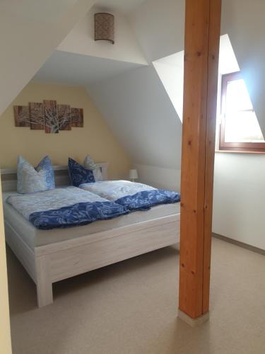 1 dormitorio con cama con sábanas azules y ventana en FW Zum Kuckucksnest auf 2 Etagen und 140qm, en Quedlinburg