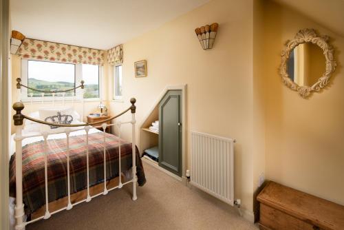 a bedroom with a bed and a mirror and a window at Gypsy Palace in Kirk Yetholm
