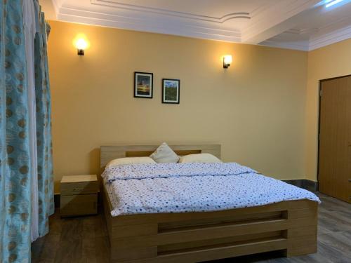 - une chambre avec un lit et deux oreillers dans l'établissement Denzong House, à Kalimpong