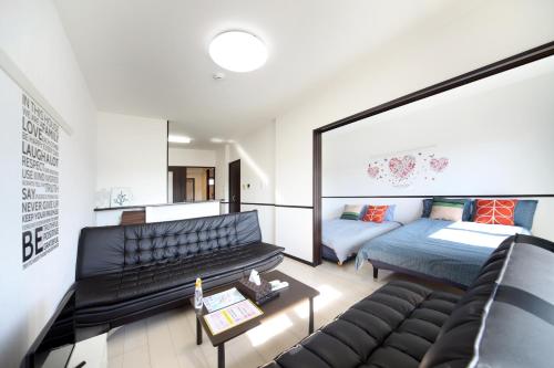 sala de estar con sofá y cama en EX Itoman Apartment 702, en Itoman