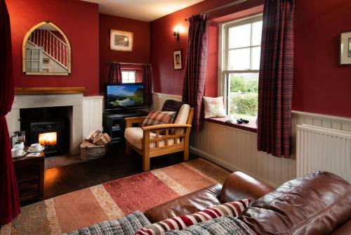 a living room with a couch and a fireplace at Gypsy Palace in Kirk Yetholm