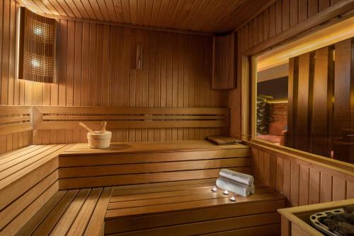a wooden sauna with a tub and a mirror at AKKA Lush Hotel Taksim in Istanbul