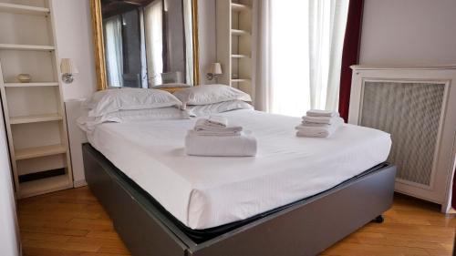 un letto con asciugamani in una camera da letto di Italianway-Corso Garibaldi 55 a Milano