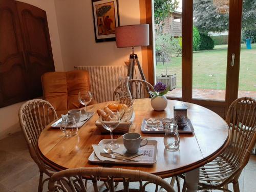 a wooden table with wine glasses and food on it at Chambre Candésie in Pouzac